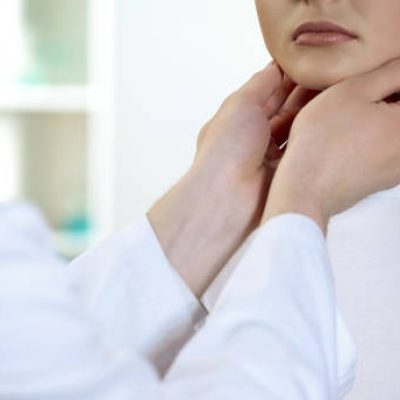 Male physician checking patient throat and neck, health examination in hospital